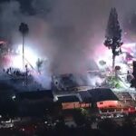 Over 100 firefighters battle fireworks blaze that leaves woman in critical condition